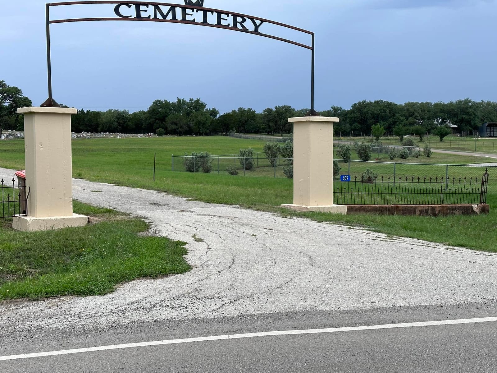 The cemetery entrance from Nugent Avenue, with the 609 address sign on the right pillar.
